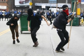 Demonstranti utíkající od policie, která použila slzný plyn.